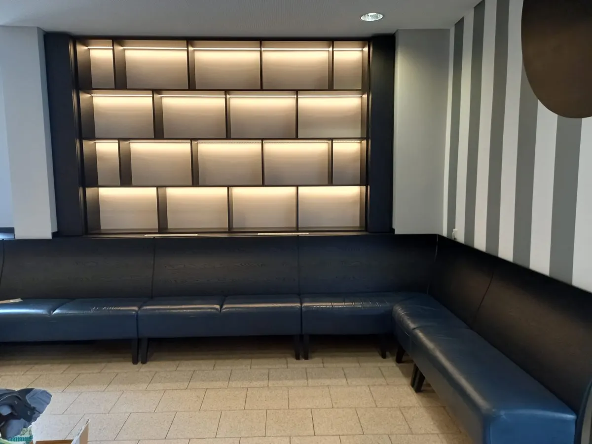 Maßgefertigte Lounge-Sitzbank mit beleuchteter Wandverkleidung in einem Hotel