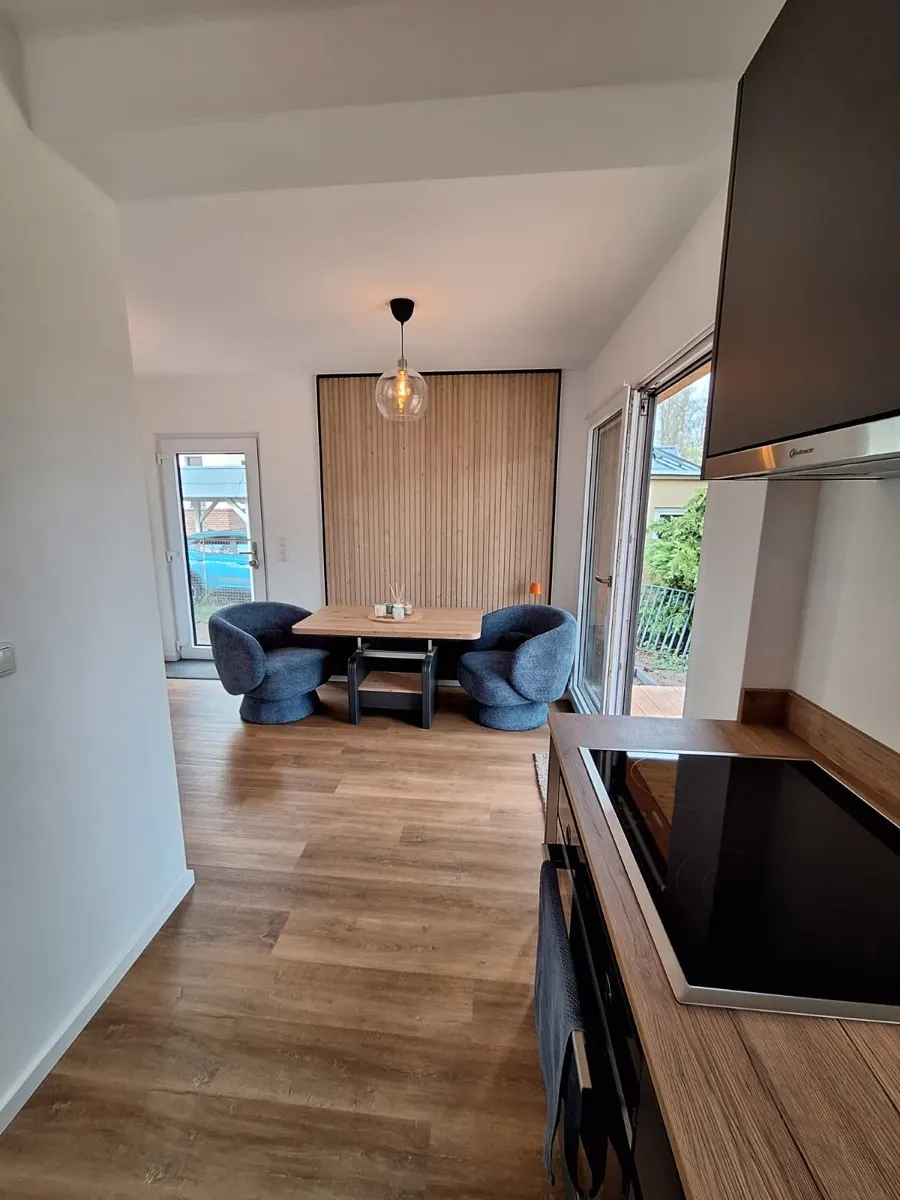 Essbereich in einem TMF Modulhaus mit Holzlamellen-Wand und Terrassenzugang